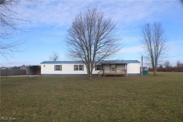 rear view of property featuring a wooden deck and a yard