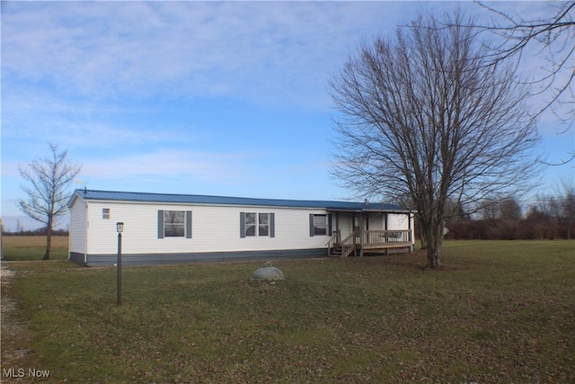 manufactured / mobile home featuring a front yard and a wooden deck