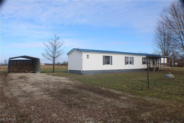 view of side of property featuring a lawn and a carport