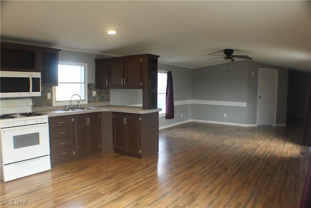 kitchen featuring white appliances, sink, decorative backsplash, ceiling fan, and dark brown cabinetry