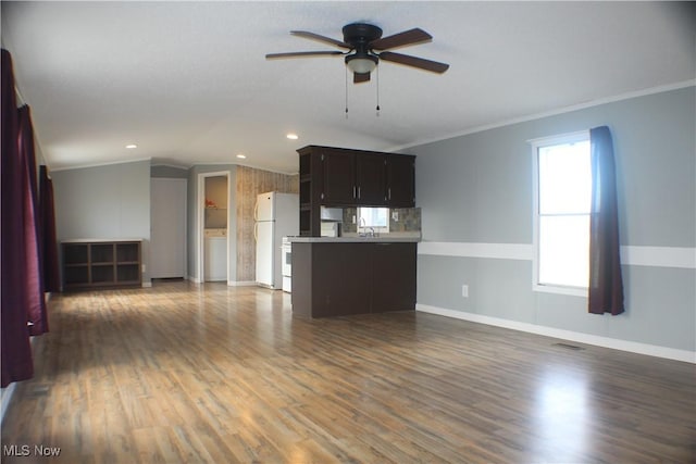 unfurnished living room with ceiling fan, dark hardwood / wood-style flooring, vaulted ceiling, and ornamental molding