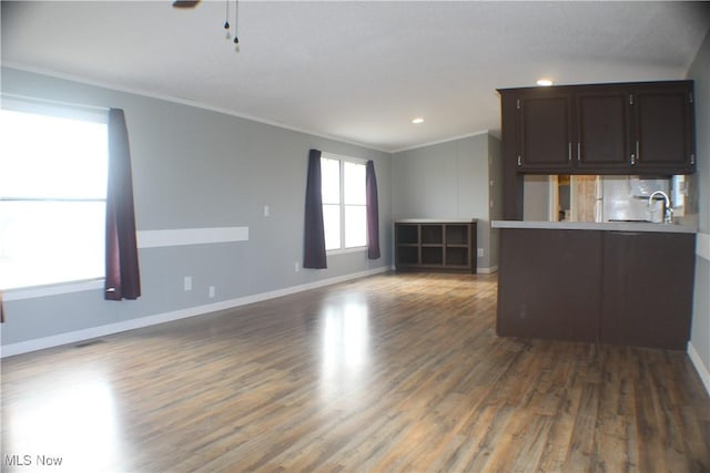 interior space featuring crown molding, plenty of natural light, and dark wood-type flooring