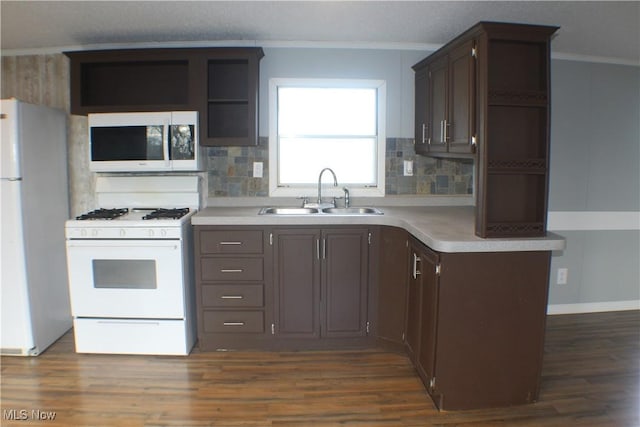 kitchen with dark brown cabinets, white appliances, ornamental molding, and sink