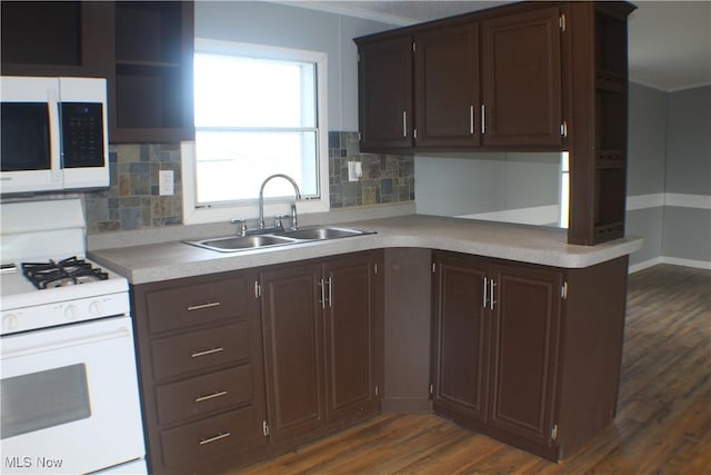 kitchen featuring backsplash, dark brown cabinets, white appliances, sink, and dark hardwood / wood-style floors