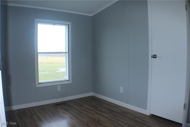 unfurnished room featuring dark hardwood / wood-style floors and ornamental molding