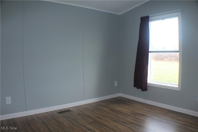 spare room featuring lofted ceiling, a healthy amount of sunlight, dark hardwood / wood-style flooring, and ornamental molding