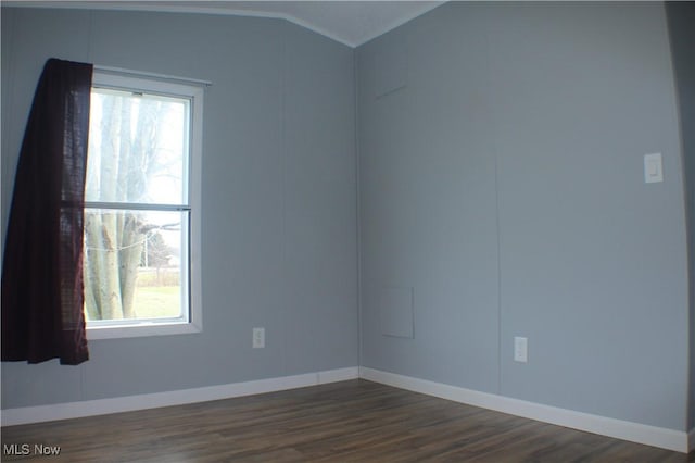 unfurnished room with dark wood-type flooring and lofted ceiling