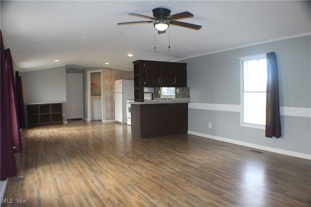 unfurnished living room featuring dark hardwood / wood-style flooring, ceiling fan, ornamental molding, and sink