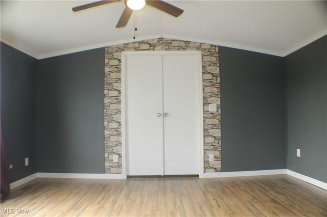 unfurnished bedroom featuring hardwood / wood-style flooring, vaulted ceiling, ceiling fan, and crown molding