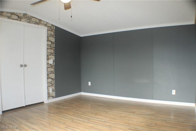 unfurnished bedroom featuring ceiling fan, lofted ceiling, crown molding, and light hardwood / wood-style flooring