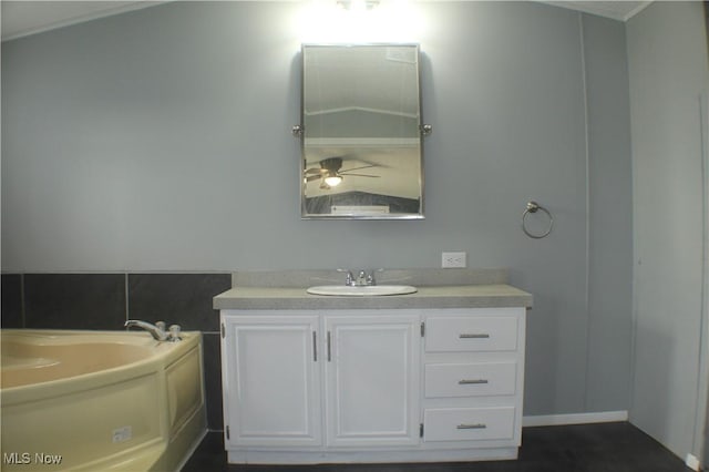 bathroom with ceiling fan, vanity, and a bath