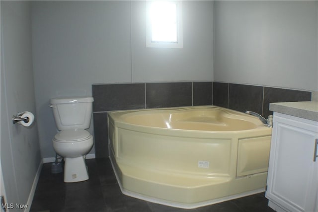 bathroom with tile patterned flooring, a bathtub, vanity, and toilet