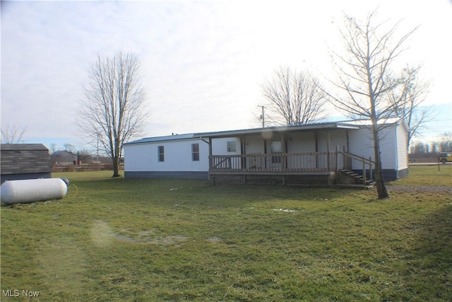 back of property featuring a lawn and a wooden deck