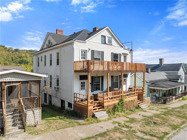 view of front of home with a balcony, cooling unit, and a sunroom