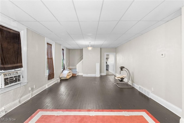 exercise area with dark hardwood / wood-style floors, cooling unit, and a drop ceiling