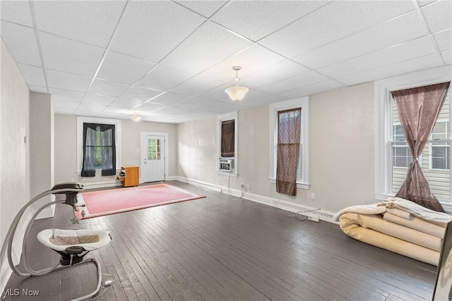 workout room featuring wood-type flooring, plenty of natural light, and a drop ceiling