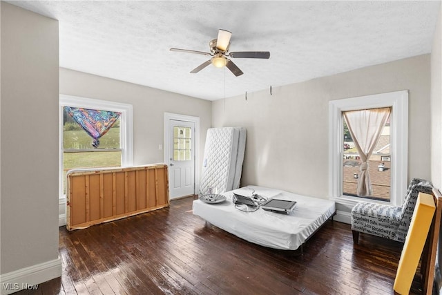 bedroom featuring a textured ceiling, dark hardwood / wood-style flooring, and ceiling fan