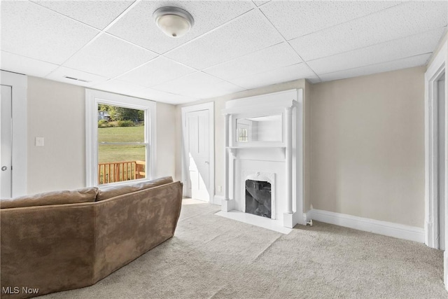 carpeted living room with a drop ceiling