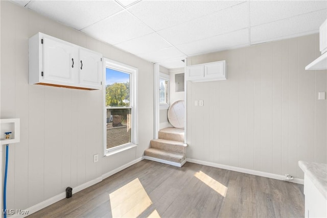 washroom with wood walls, light wood-type flooring, and hookup for a washing machine