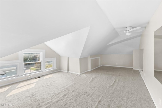 additional living space featuring ceiling fan, lofted ceiling, and light carpet