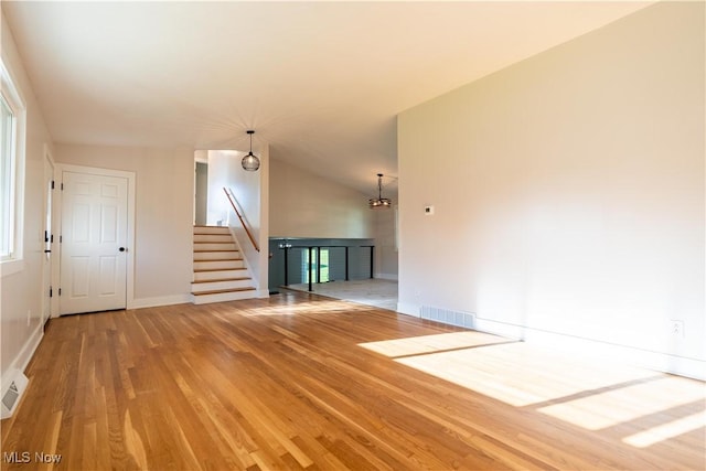 unfurnished room featuring lofted ceiling and hardwood / wood-style flooring