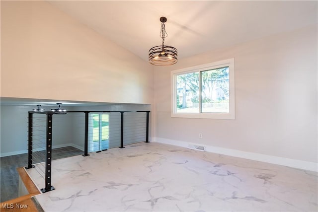 unfurnished room with vaulted ceiling