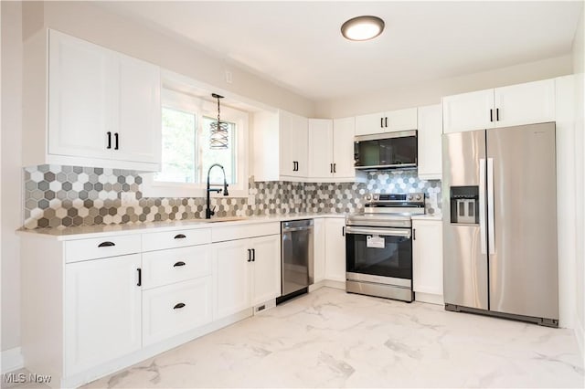 kitchen featuring pendant lighting, stainless steel appliances, white cabinetry, and sink