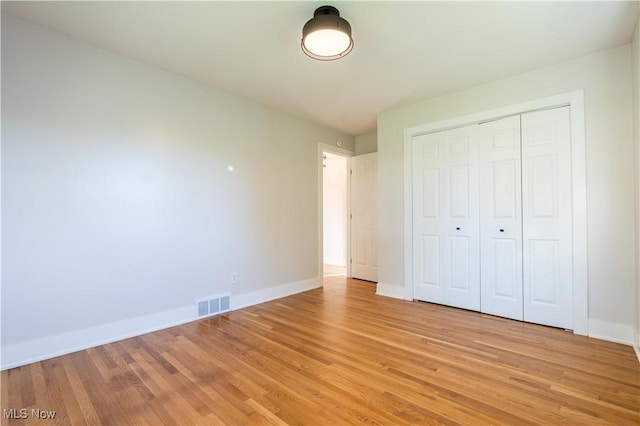 unfurnished bedroom with light hardwood / wood-style flooring and a closet