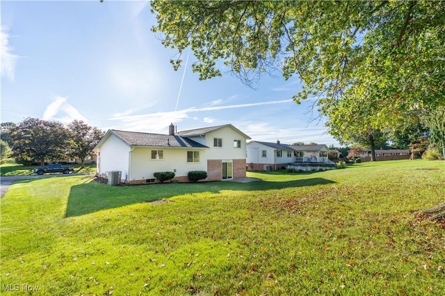 view of side of home with a lawn and central AC