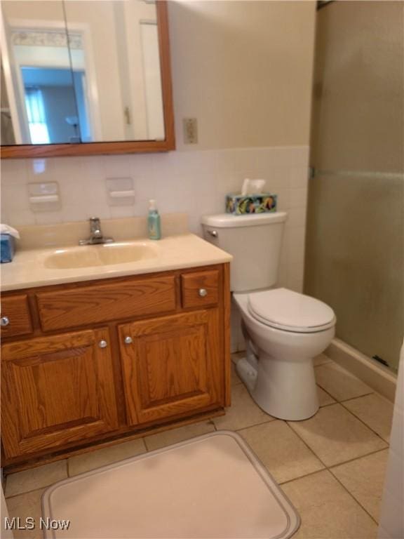 bathroom with toilet, vanity, tile patterned floors, and an enclosed shower