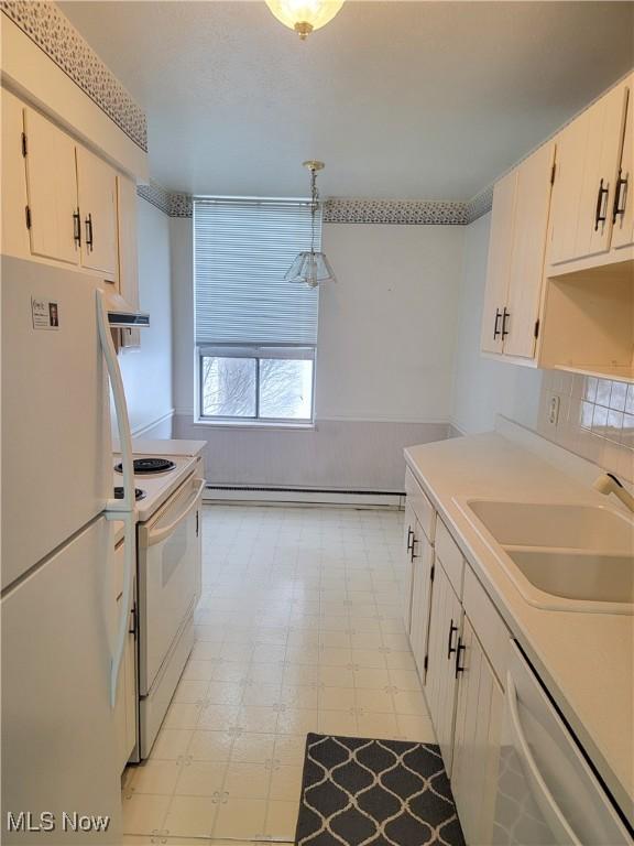 kitchen with white appliances, sink, pendant lighting, a baseboard radiator, and white cabinetry