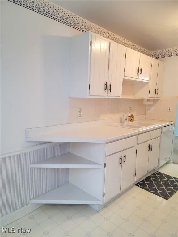 kitchen with white cabinetry, sink, and white dishwasher