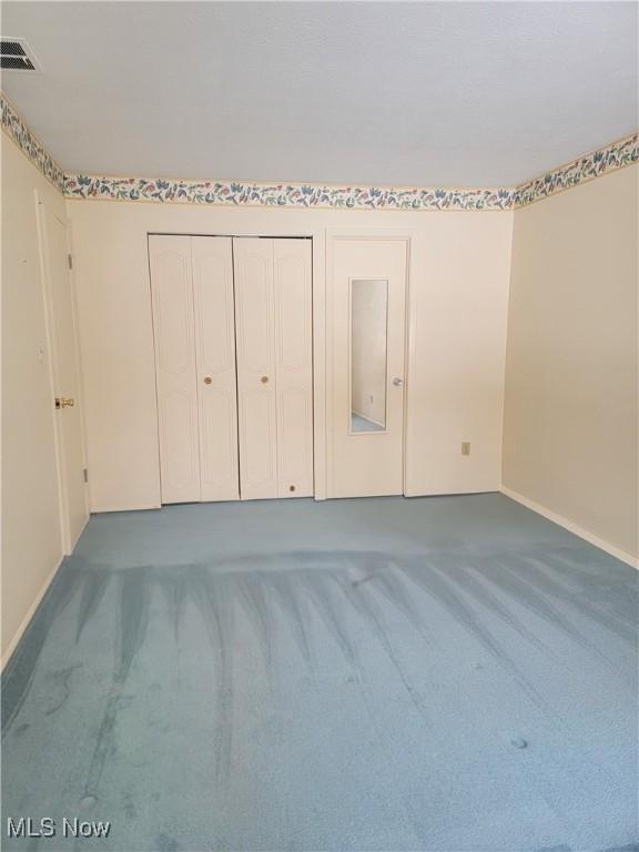 unfurnished bedroom with dark carpet