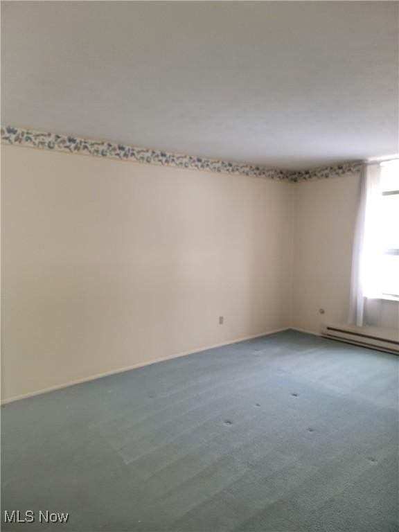 carpeted spare room featuring a baseboard radiator