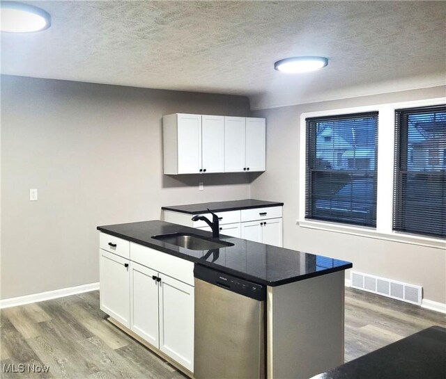 kitchen featuring dark wood-type flooring, sink, white cabinets, and stainless steel dishwasher