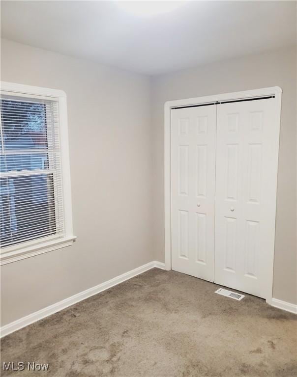 unfurnished bedroom featuring carpet flooring and a closet