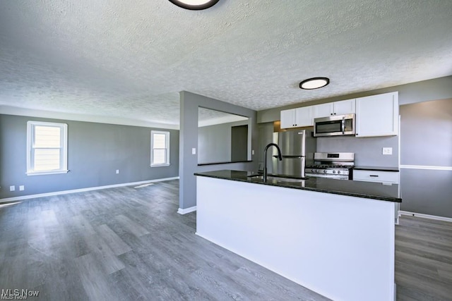 kitchen featuring sink, appliances with stainless steel finishes, dark hardwood / wood-style floors, a textured ceiling, and white cabinets