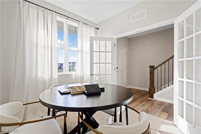 dining room with hardwood / wood-style flooring and french doors