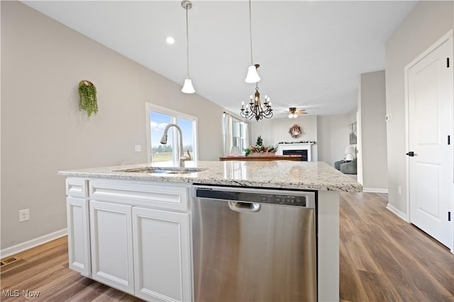 kitchen with white cabinetry, sink, stainless steel dishwasher, hardwood / wood-style floors, and a kitchen island with sink