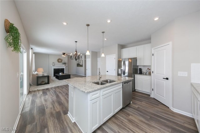 kitchen featuring a kitchen island with sink, white cabinets, appliances with stainless steel finishes, and a sink