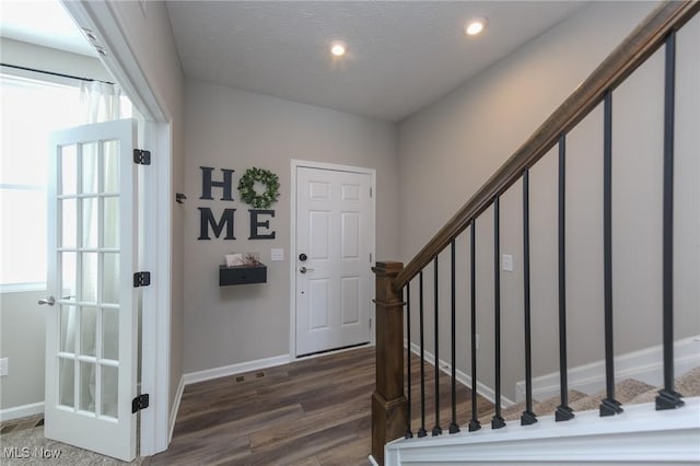 foyer featuring stairs, baseboards, recessed lighting, a textured ceiling, and dark wood-style flooring