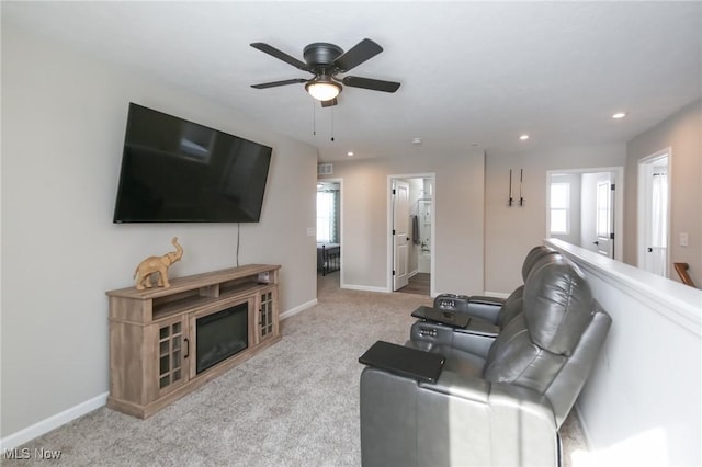 living room featuring baseboards, light carpet, and a healthy amount of sunlight