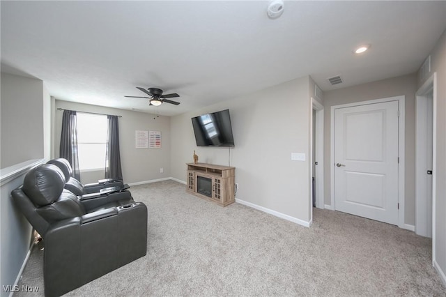 living room with baseboards, visible vents, light colored carpet, a fireplace, and ceiling fan