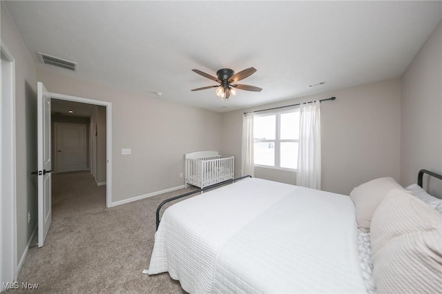 bedroom featuring light colored carpet, ceiling fan, visible vents, and baseboards