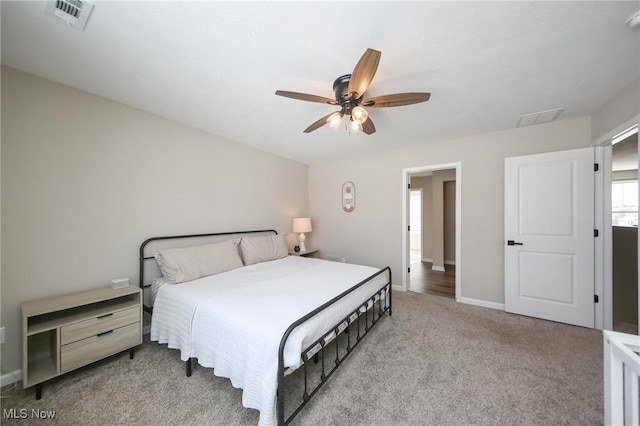 bedroom with baseboards, visible vents, light colored carpet, and ceiling fan