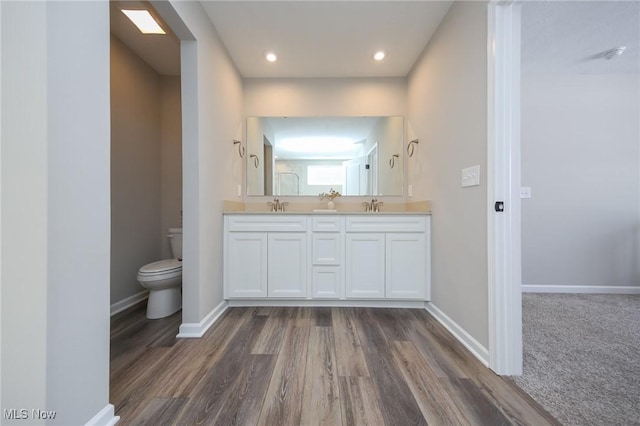 full bathroom featuring a sink, baseboards, and double vanity