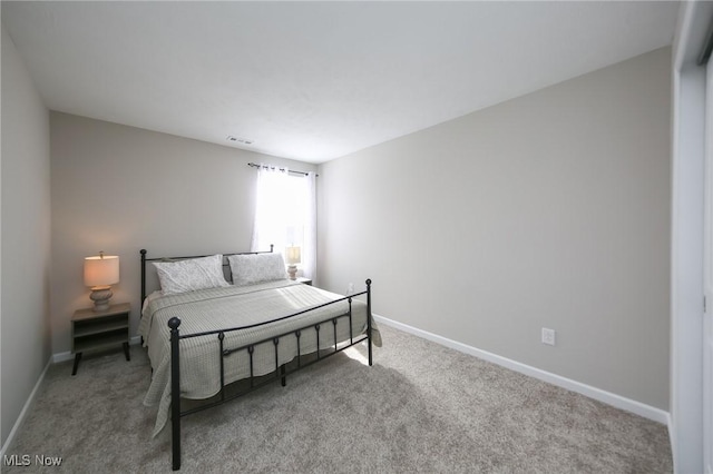 bedroom featuring baseboards, visible vents, and light carpet