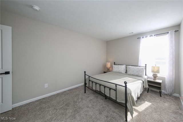 bedroom with baseboards and carpet