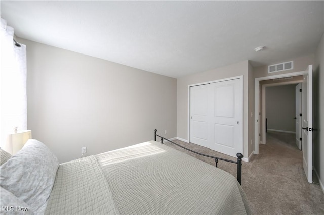 bedroom featuring baseboards, visible vents, a closet, and carpet flooring