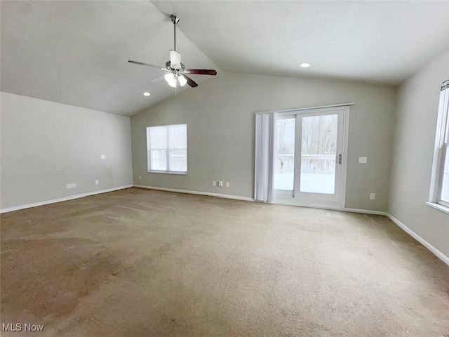 unfurnished room with carpet, vaulted ceiling, ceiling fan, and a healthy amount of sunlight